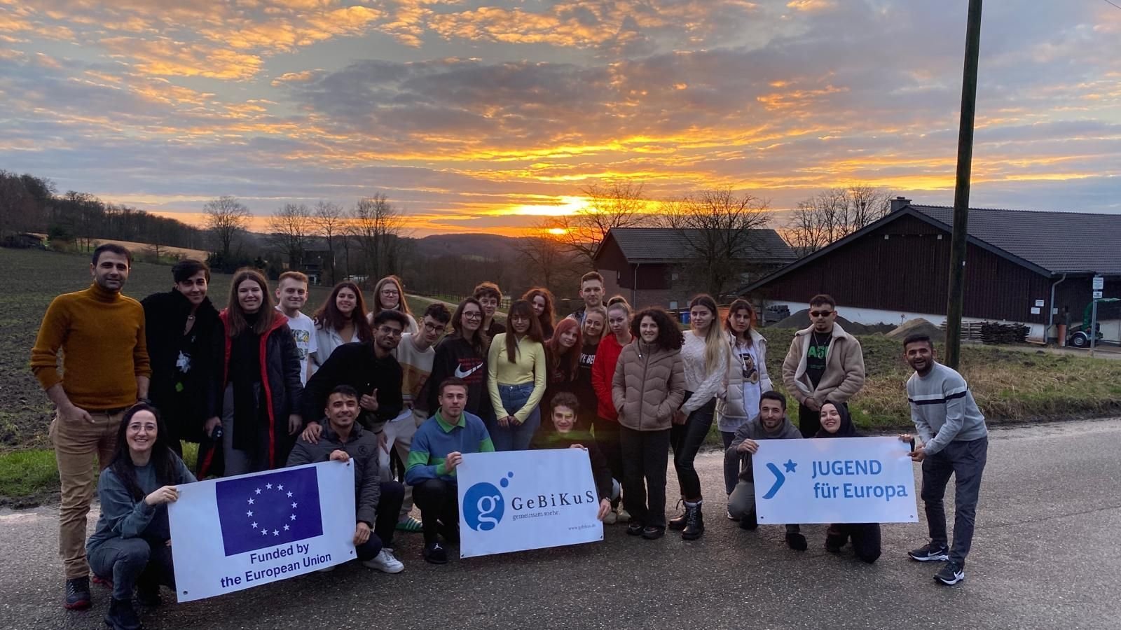 Gruppe bei Sonnenuntergang mit Bannern der Europäischen Union, GeBiKuS und Jugend für Europa